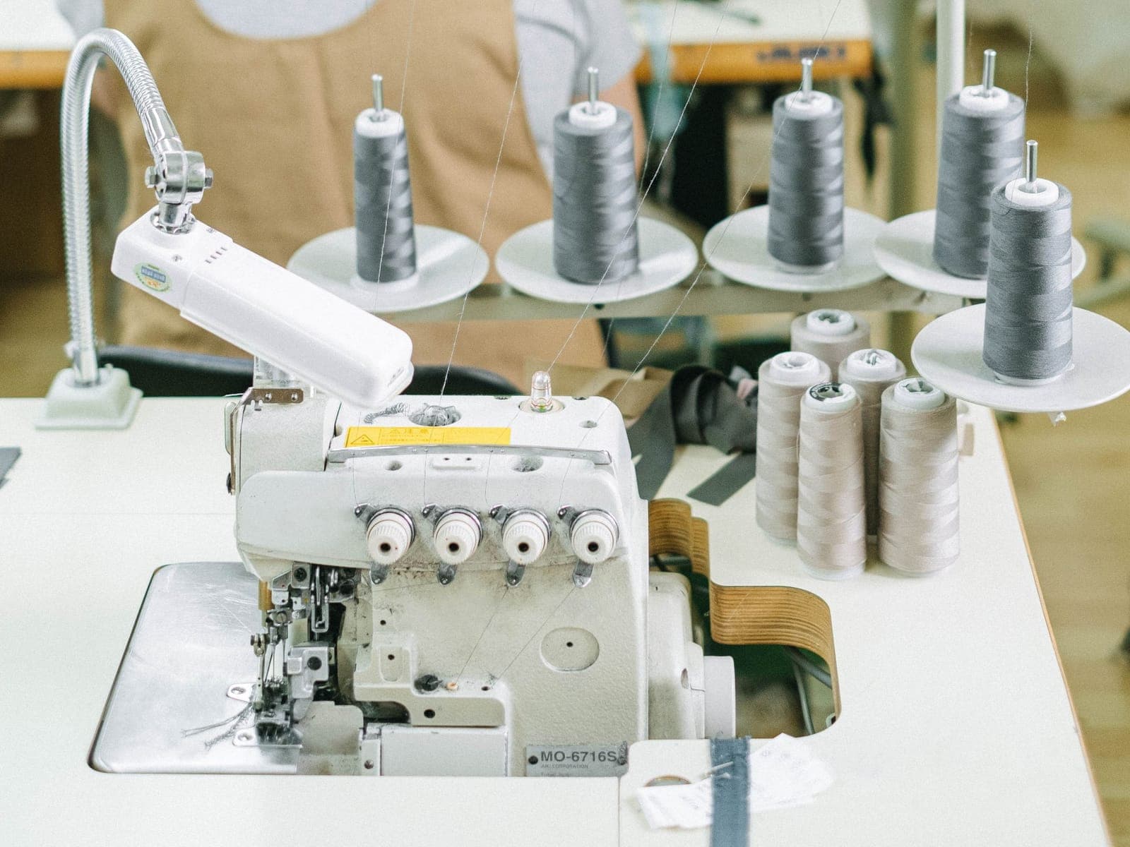 Embroidery machine set up with thread cones, applying branding to a garment