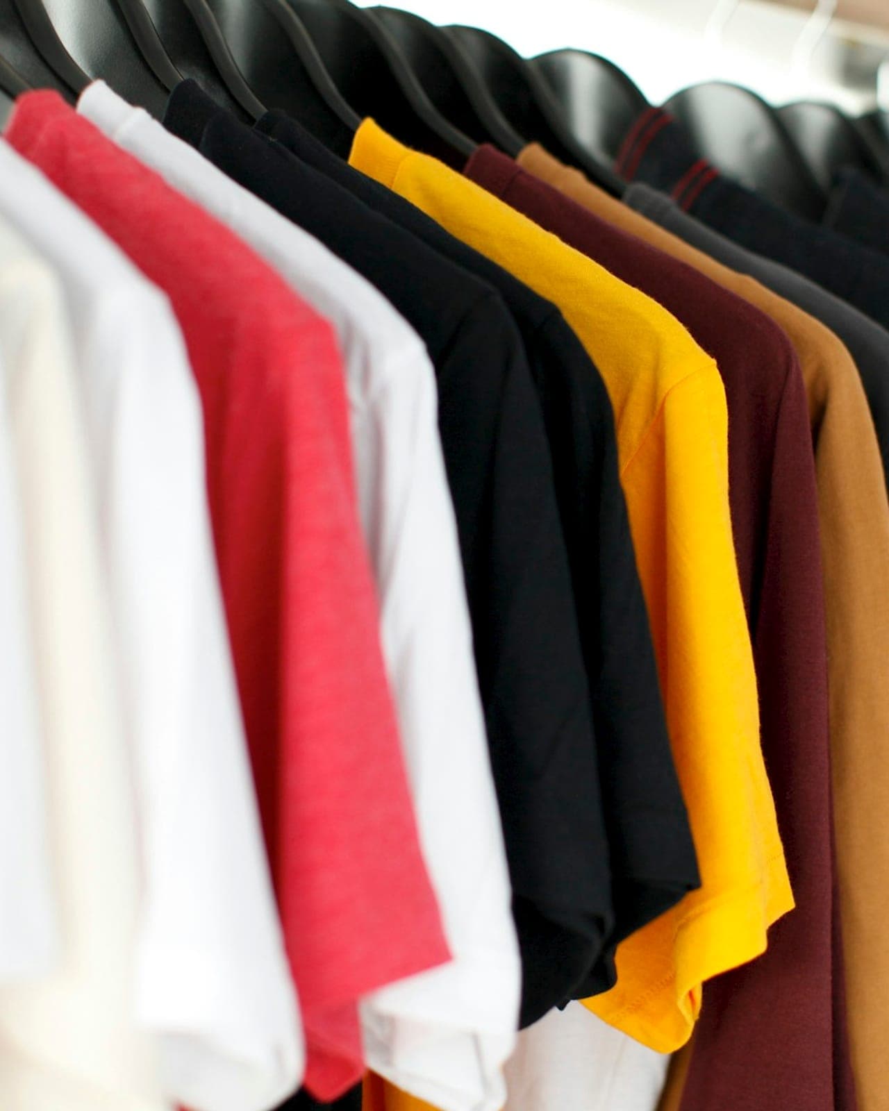 Rail of plain T-shirts in a range of colours, ready for private-label branding